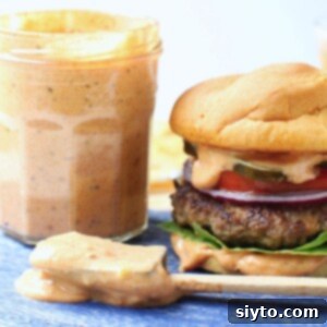 thumbnail photo - jar of secret burger sauce next to a burger loaded with toppings and dripping burger sauce.