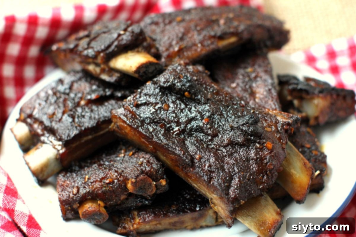 A plate generously piled high with perfectly glazed, spicy ribs, ready for serving and enjoying. They look moist, tender, and incredibly flavorful.