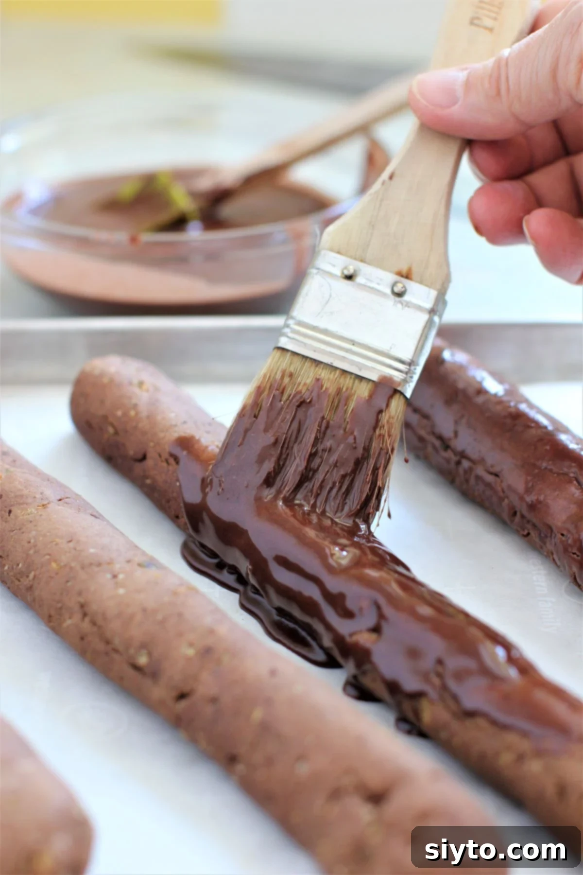 brushing the baked strips of dough with chocolate icing.