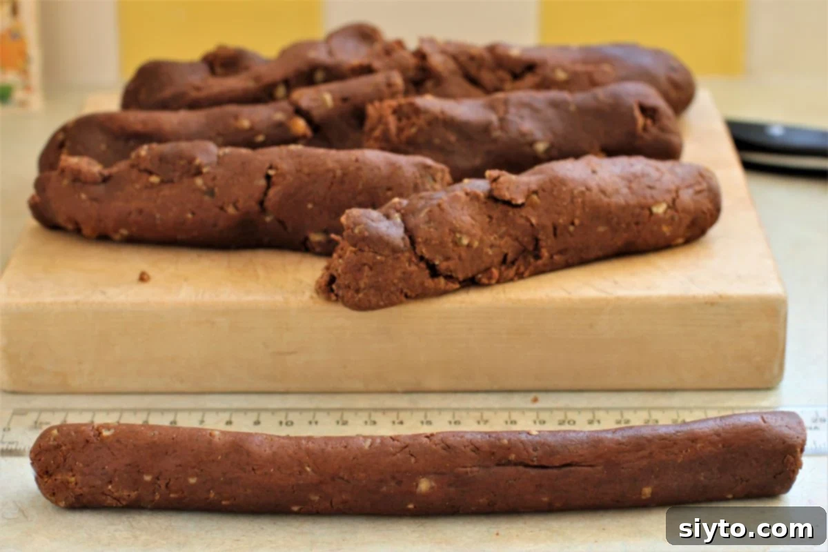a rolled strip of dough in front of the cutting board.