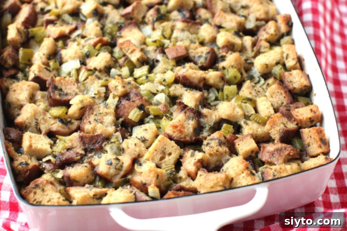 A horizontal close-up shot of the end of a pan filled with beautifully baked gluten-free stuffing, showing its crispy, golden-brown top layer.