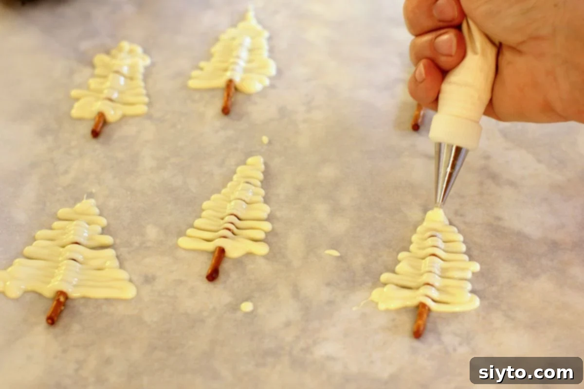 piping trees out of white chocolate onto pretzel stems.