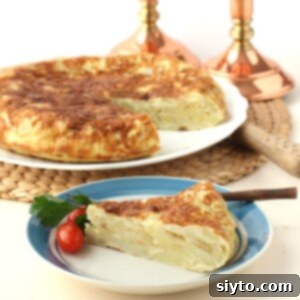 square photo of a slice of tortilla de patatas on a blue-rimmed plate, in front of the whole tortilla.