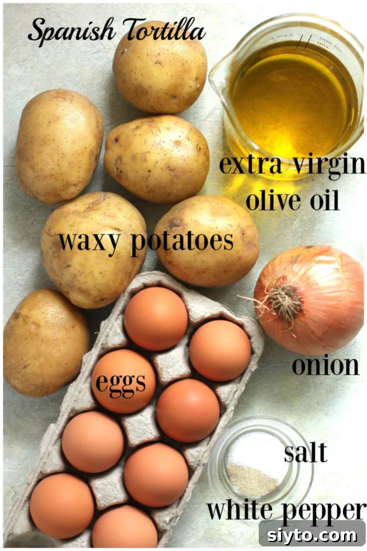 whole potatoes, brown eggs, an onion, olive oil, salt, white pepper - laid out on counter and labeled.