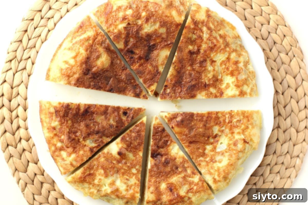 top down view of the Tortilla de Patatas on a white plate, cut into 7 wedges.