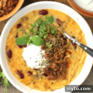 Aush soup thumbnail, top-down view of bowl of aush, topped with yogurt sauce and meat.