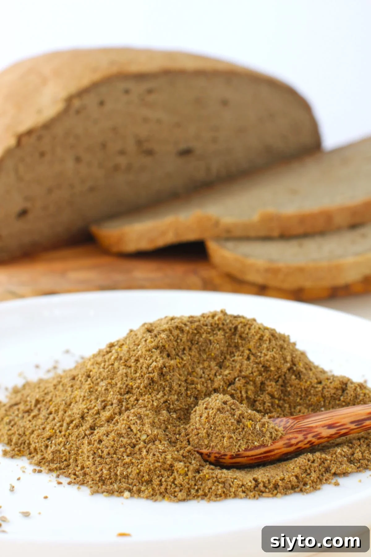 mound of bread spice with sliced loaf of homemade deli-style bread behind.