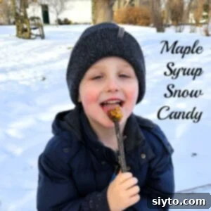 A young boy, Caleb, happily licking his homemade maple syrup snow candy on a stick.