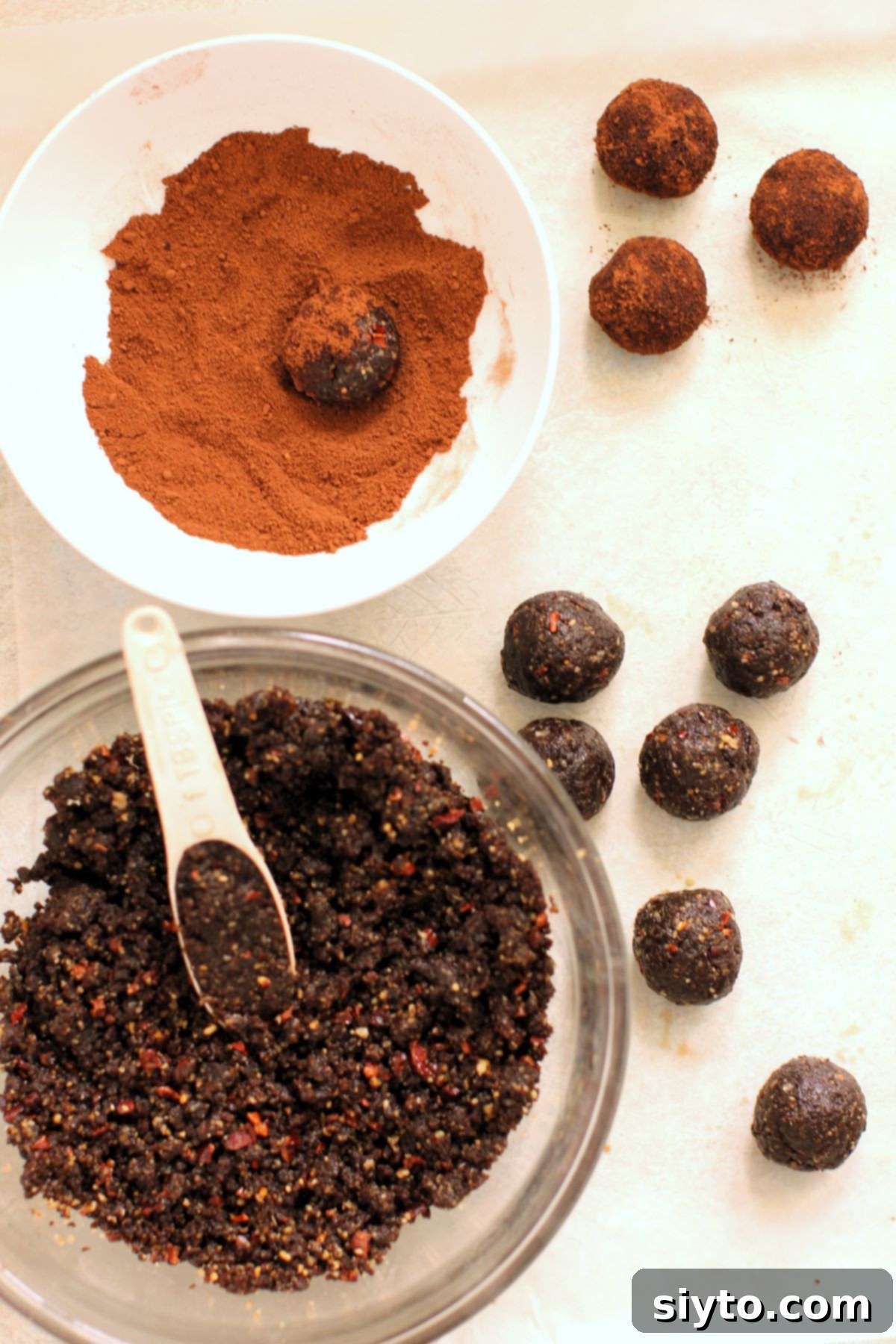 Sweet Bites Snowy Sleds: Lake Louise Adventures 16 A close-up shot showing the process of rolling dark, round black licorice balls and generously coating them in a spiced sugar mixture.