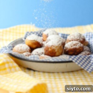 square thumbnail of powdered sugar sprinkling down on a plate of Aebleskiver.