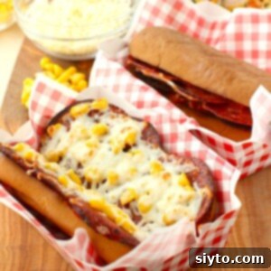 Square thumbnail of a finished pizza dog on red checked paper, served on a hot dog plate.