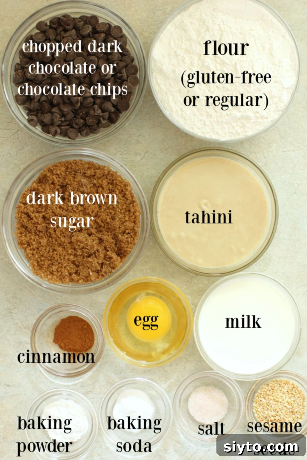 Bowls of dark chocolate, tahini, brown sugar, flour, and other ingredients neatly arranged for making soft chocolate tahini cookies.
