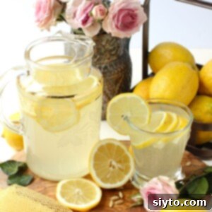 A thumbnail photo featuring a pitcher of Omani rosewater lemonade, a glass filled with the refreshing drink, and vibrant lemon slices for garnish.