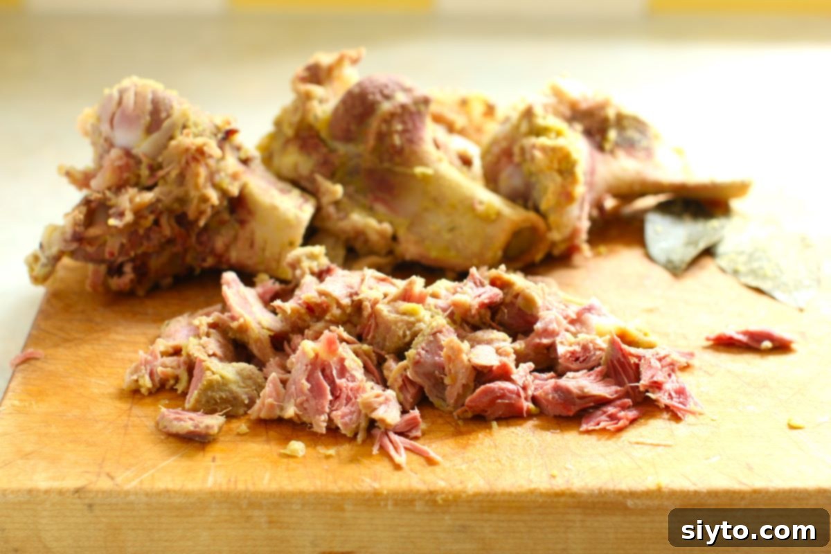 Perfectly Simple Split Pea Soup 8 shredded ham on a cutting board, ham bones behind.