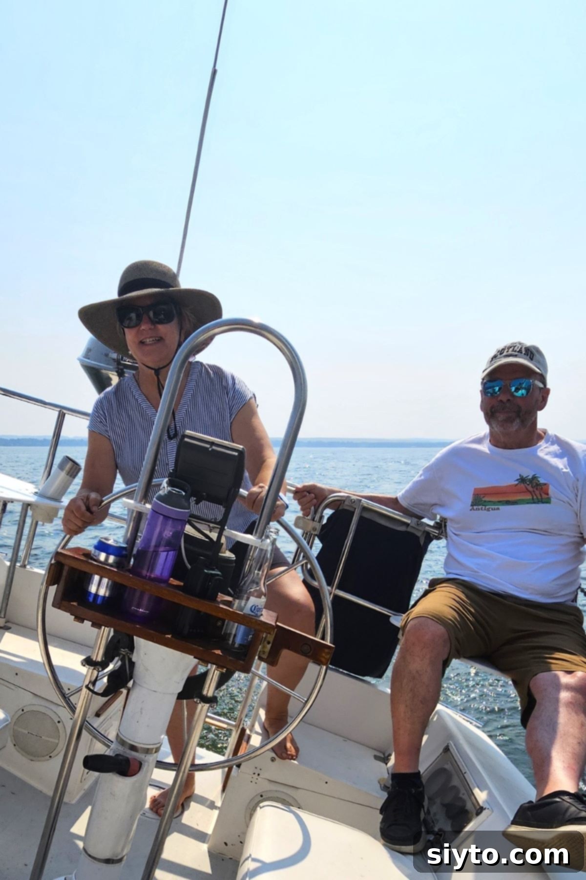 The author confidently steering a sailboat at the tiller, with Raymond seated nearby, enjoying the ride.