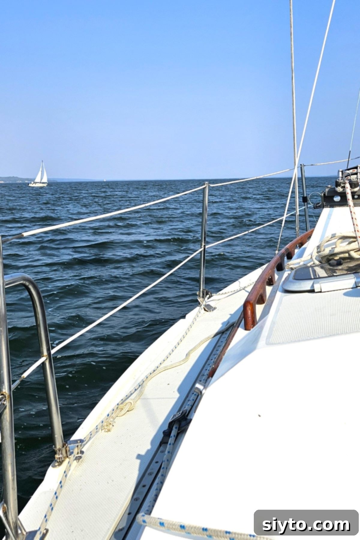 A picturesque view of Wabamun Lake in Alberta under a clear sky, showing calm waters and distant trees, capturing a stunning summer day.