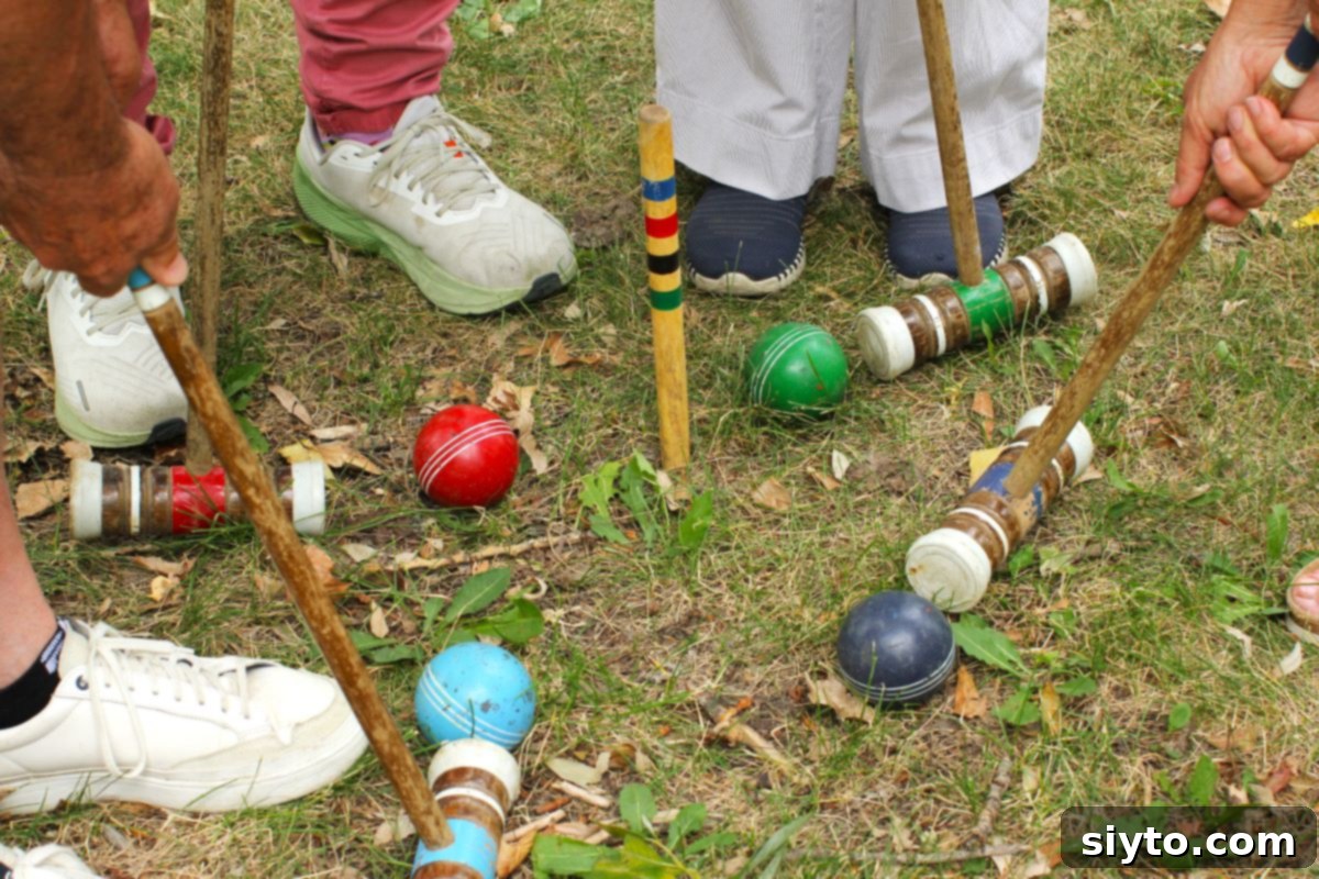 Close-up shot of croquet mallets and balls resting on the grass, with sets of feet visible, indicating the conclusion of a lively game.