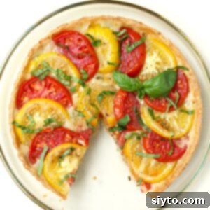 Rustic Tomato Tart 14 Square thumbnail photo of the tomato tart from the top, with a slice cut out of it.