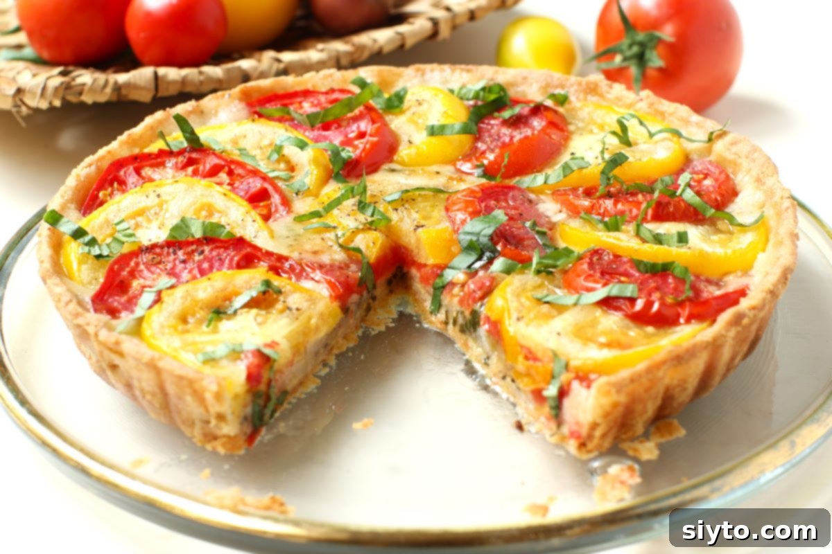 Rustic Tomato Tart 5 A perfectly baked tomato tart with a single wedge neatly cut out, ready to be served and enjoyed.