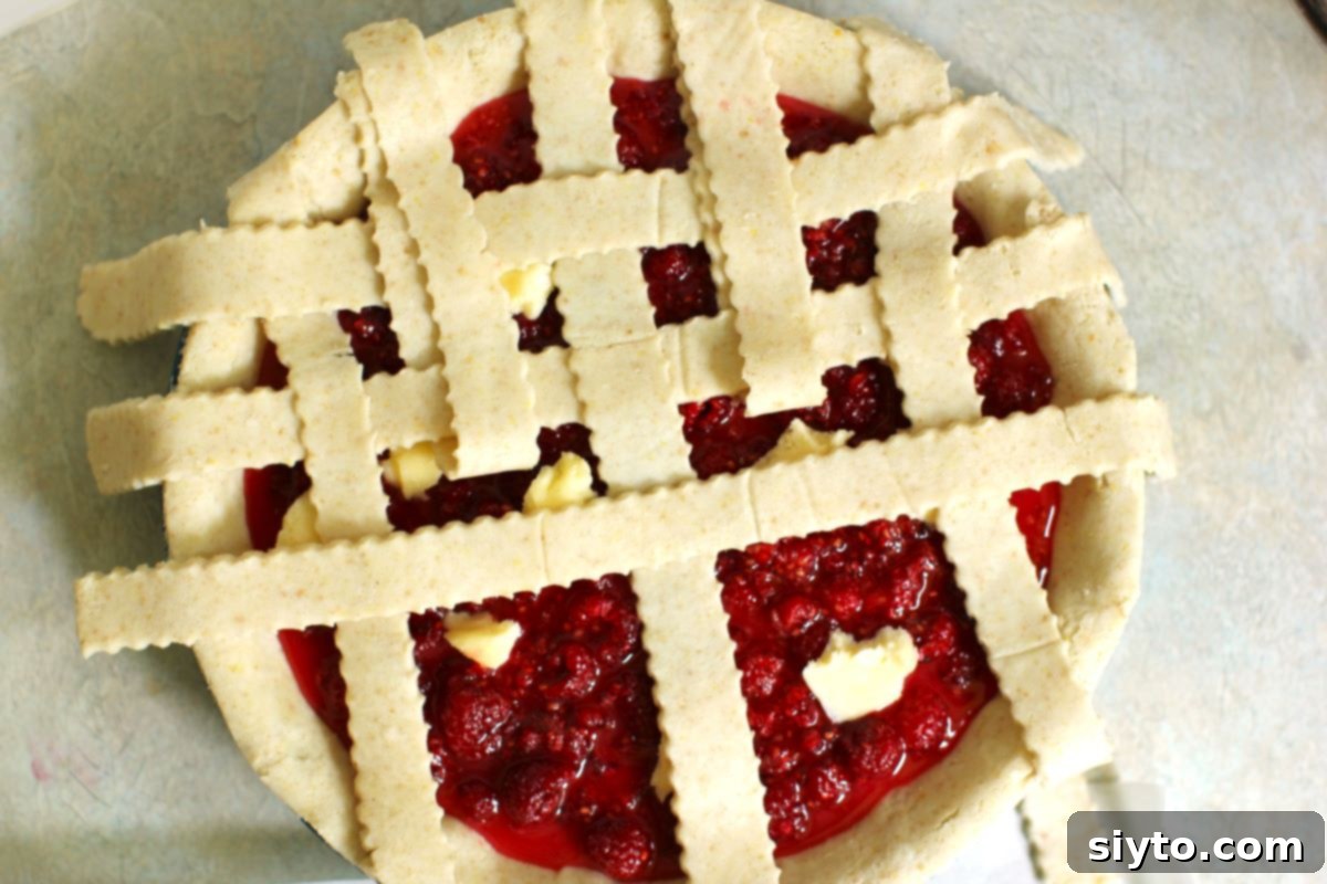a half-finished lattice crust on the top of the pie, showing the weaving technique.