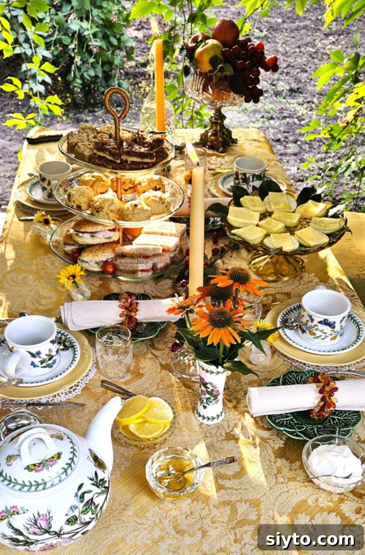 A delightful top-down view of the afternoon tea table, beautifully set in the arbour with an abundance of food, including the star Butter Pecan Bars on the top tier of the cake stand.