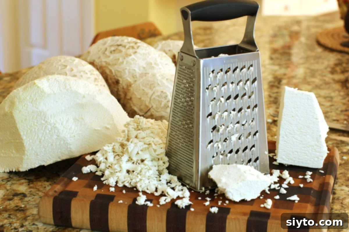 shredding the puffball on a handheld grater on a cutting board.