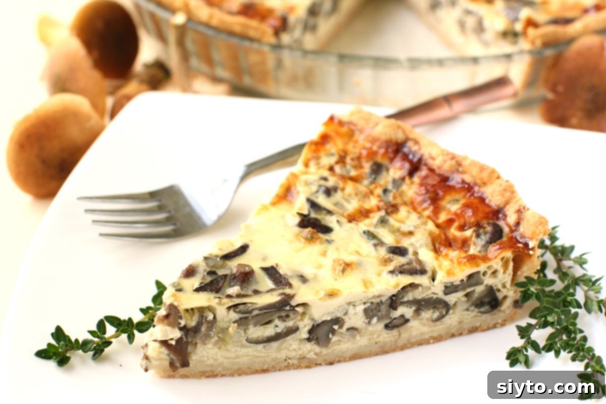 Foraged Fungi Quiche with a Gluten-Free Base 11 A slice of mushroom quiche on a white plate with thyme sprigs beside it.