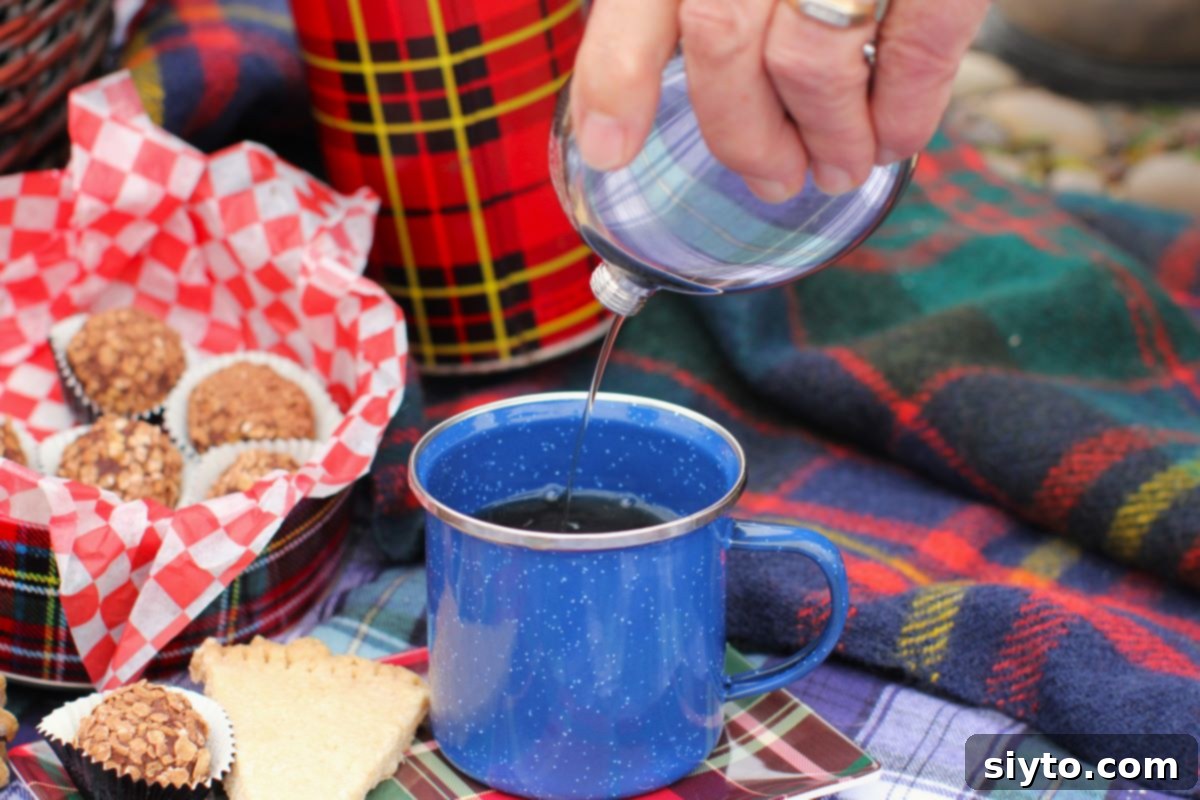 pouring Scotch whisky into the blue tin mug.