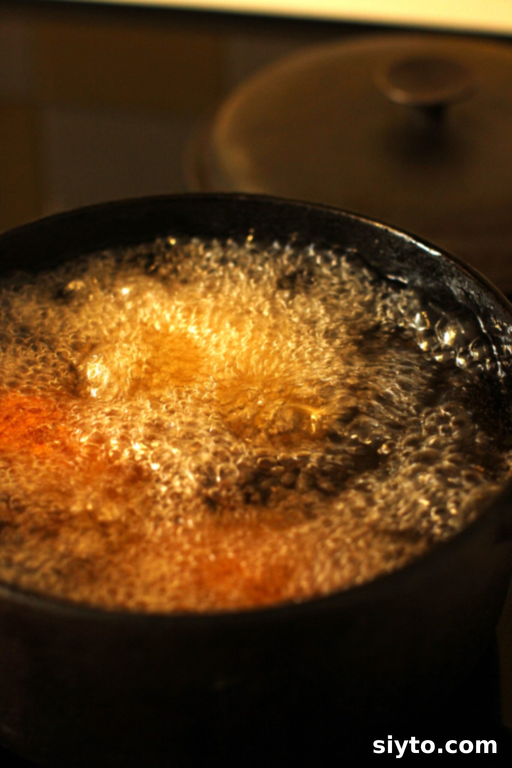 Scotch eggs bubbling away in the hot oil.