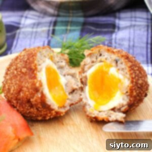 Thumbnail photo of a Scotch Egg cut open and the yolk oozing out.