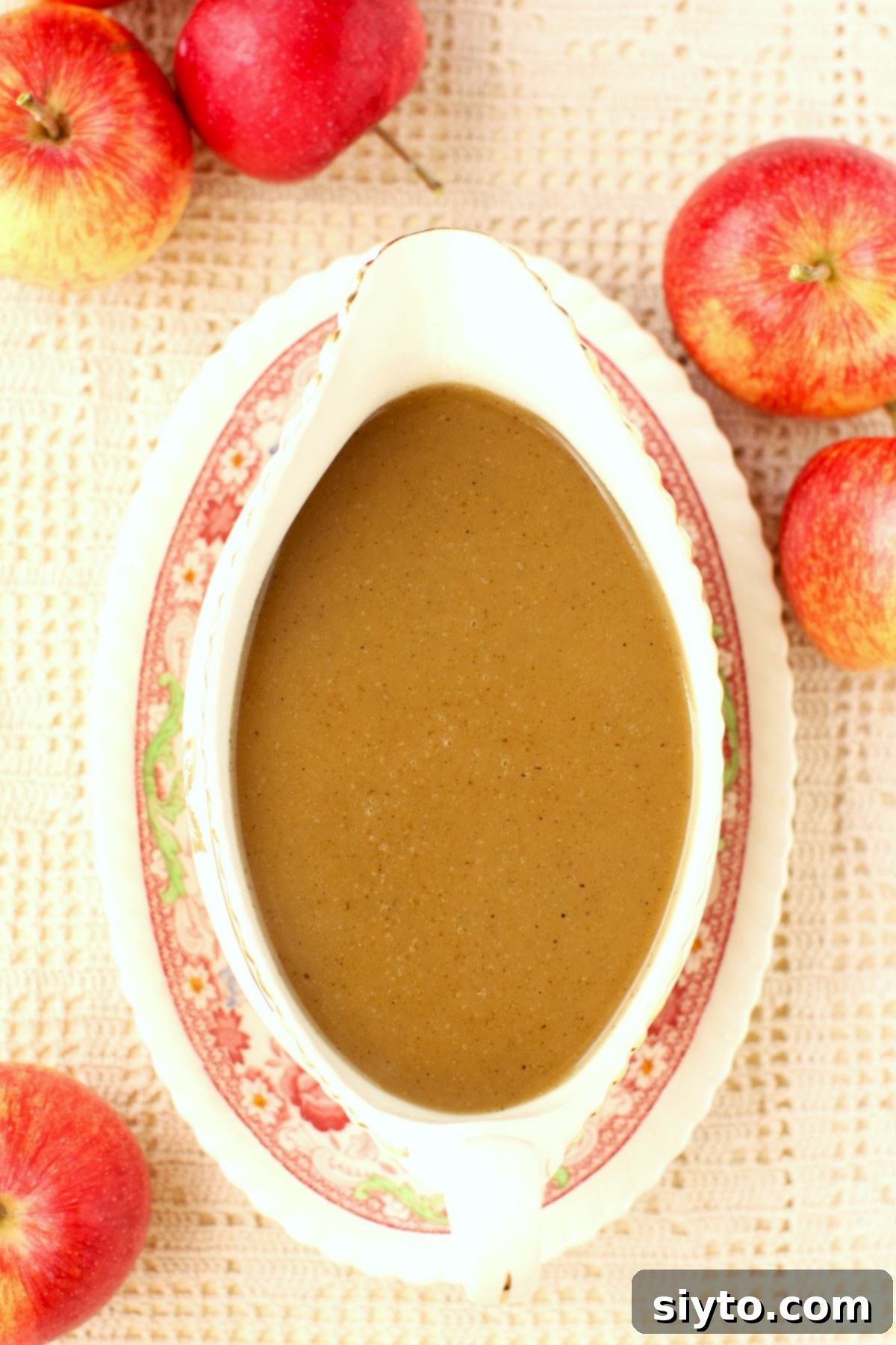 Apple Day From Press to Gravy Pot 12 Top down view of a gravy boat filled with apple cider gravy, a few apples beside it.