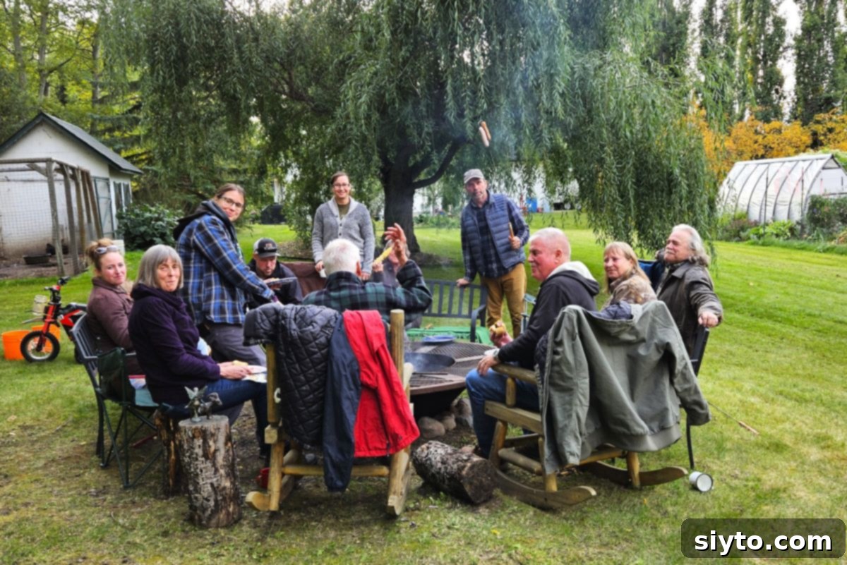 Apple Day From Press to Gravy Pot 6 Lots of people sitting around the campfire after an apple cider pressing work bee.