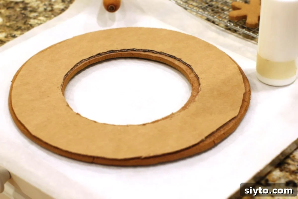 Gingerbread cookie wreath form with a cardboard circle securely glued to the back for structural reinforcement, ready for hanging.
