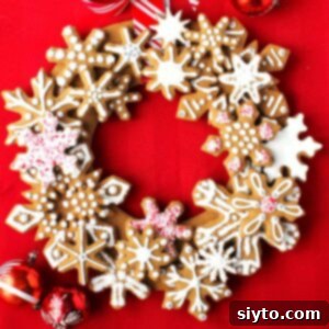 Snowflake Gingerbread Cookie Wreath on a red background with red Christmas ball ornaments. A festive edible decoration.