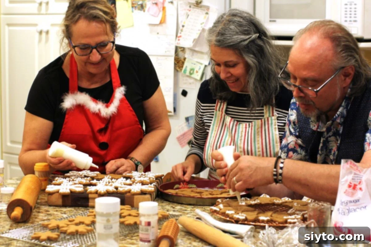 Margaret, Nicoletta, and Loreto happily icing gingerbread cookies in the kitchen during their annual Christmas Baking Bonanza.