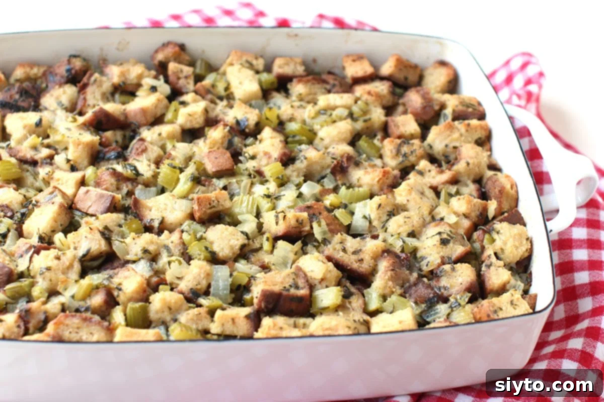 A pristine white roasting pan, perfectly filled with a generous and even layer of uncooked stuffing, ready for the turkey pieces.