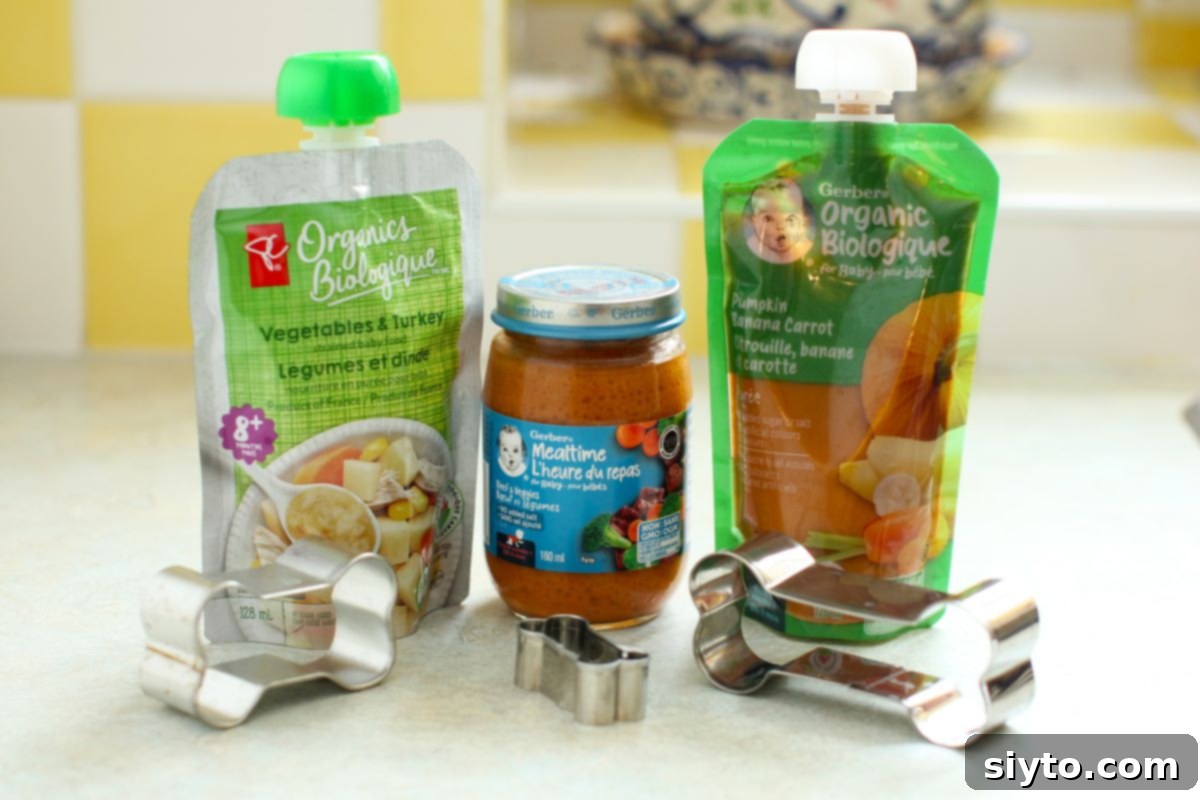 Assorted jars and pouches of baby food displayed on a kitchen counter, alongside a few bone-shaped cookie cutters, ready for making dog treats.