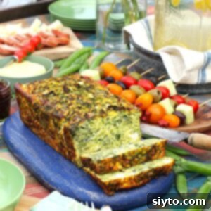 Thumbnail photo of a perfectly baked zucchini frittata loaf resting on a blue cutting board, ready to be served.