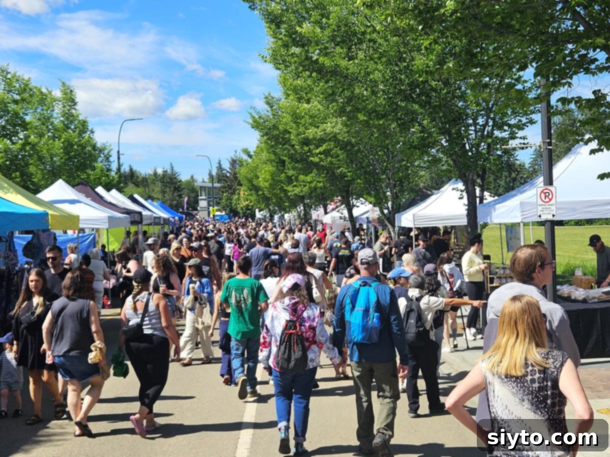 A bustling, crowded street scene at the St. Albert Farmers' Market, showcasing numerous vendors and shoppers enjoying the lively outdoor event.