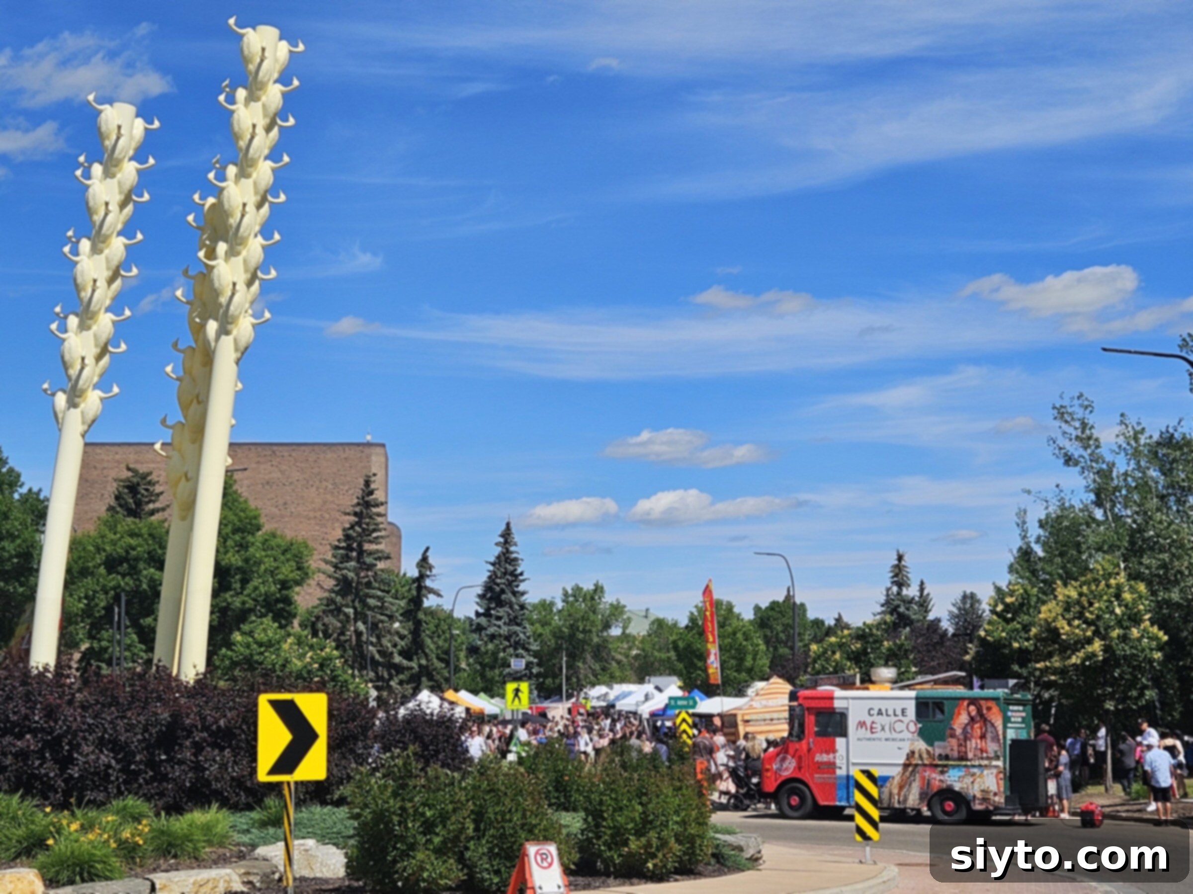 Three distinctive slanted yellow poles, each topped with a goose statue, stand as an artistic landmark at one end of the farmers' market.
