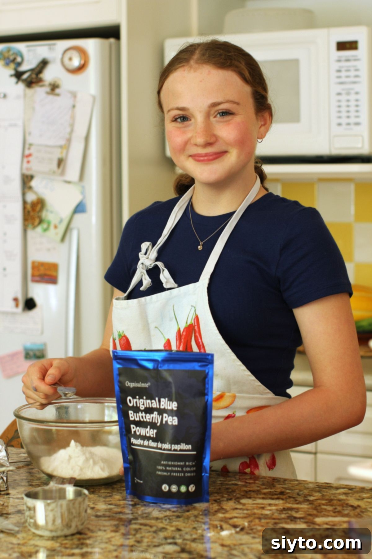 Amelia, wearing an apron, happily stirring a batch of donut dough in the kitchen, focused and engaged in the baking process.