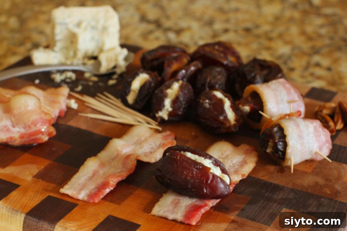 Checkered cutting board with stuffed dates, bacon, and cheese, and a stuffed date laying on a piece of bacon, ready to roll up.