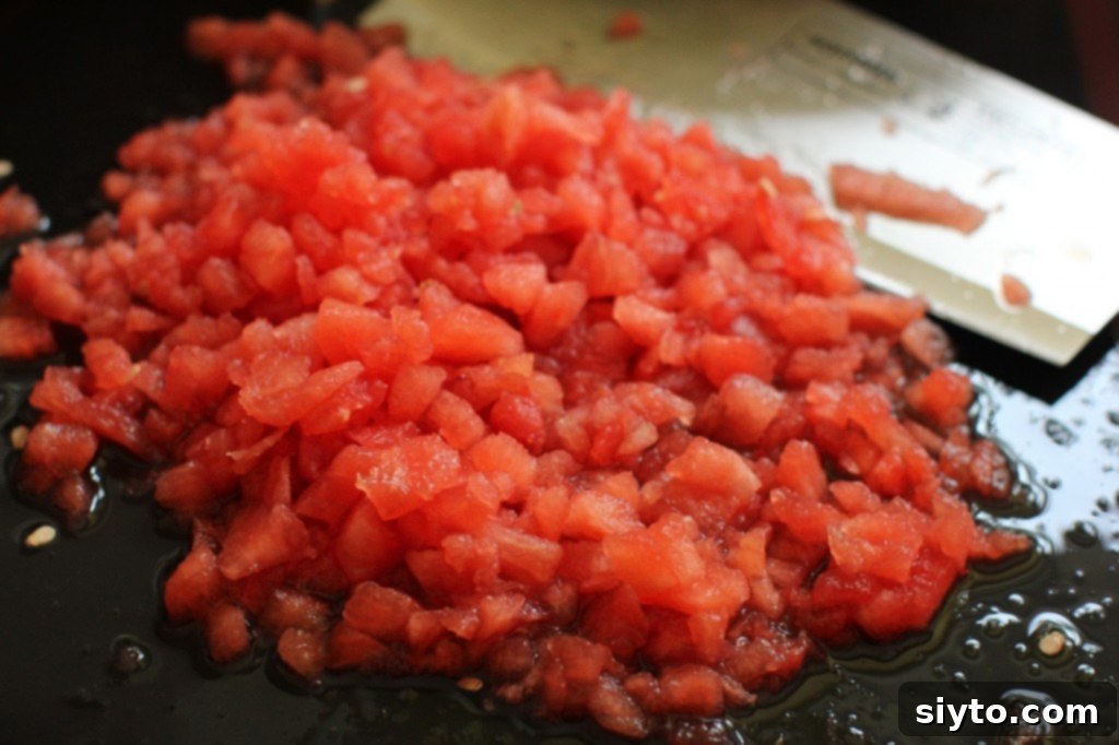Finely chopped watermelon pieces in a colander, draining liquid for salsa